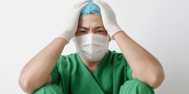 başını ellerinin arasına almış sağlık çalışanı